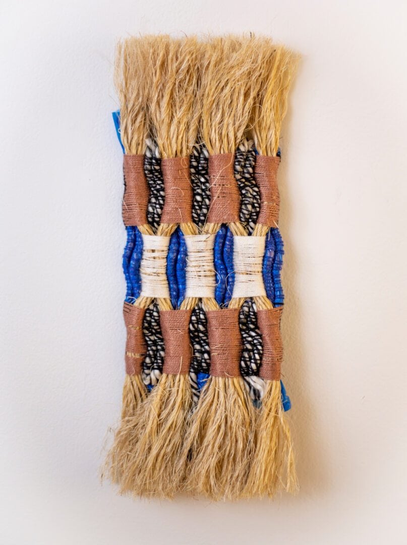 Woven wall hanging with blue and brown accents.