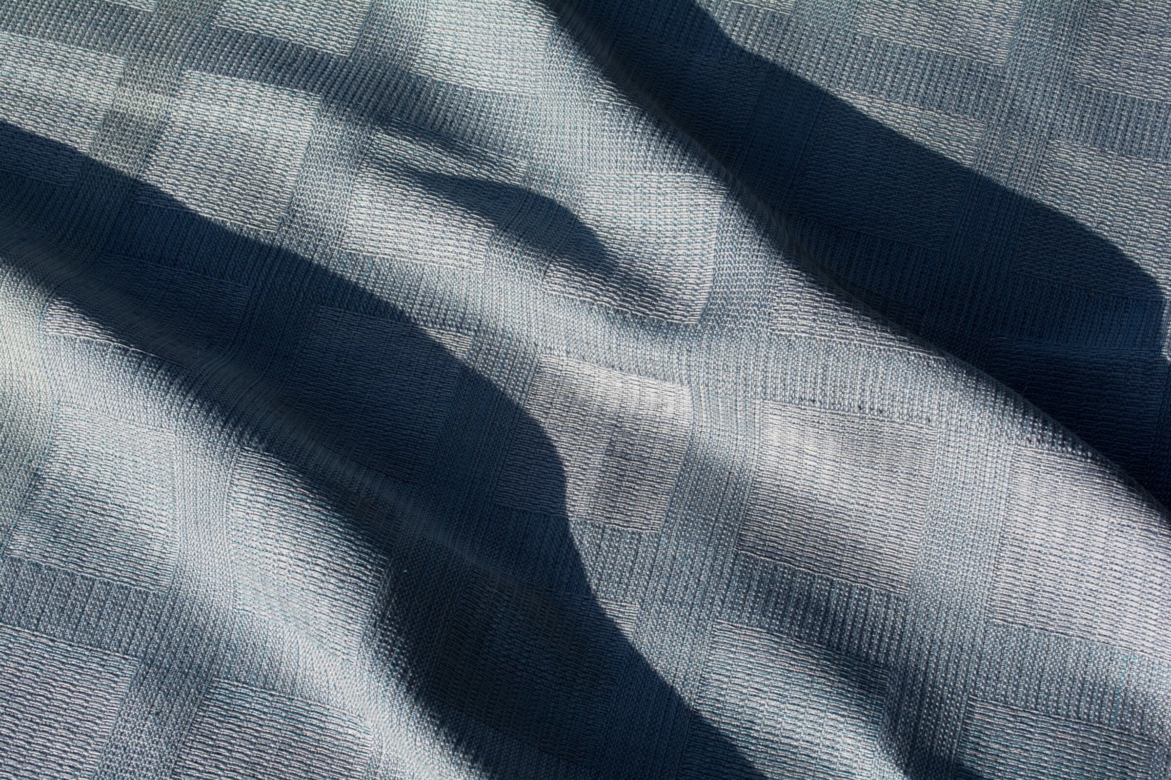 Blue checkered fabric with shadows.