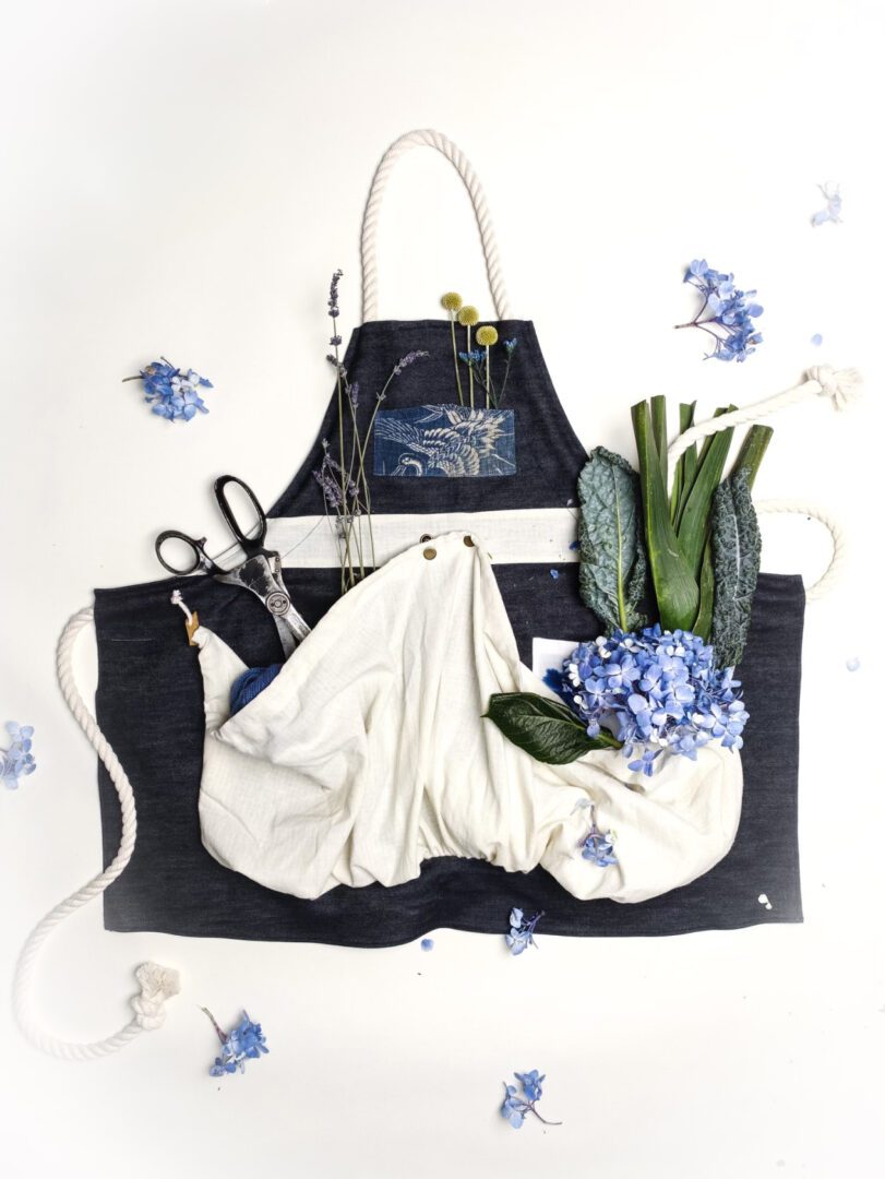 Blue denim apron with flowers and tools.