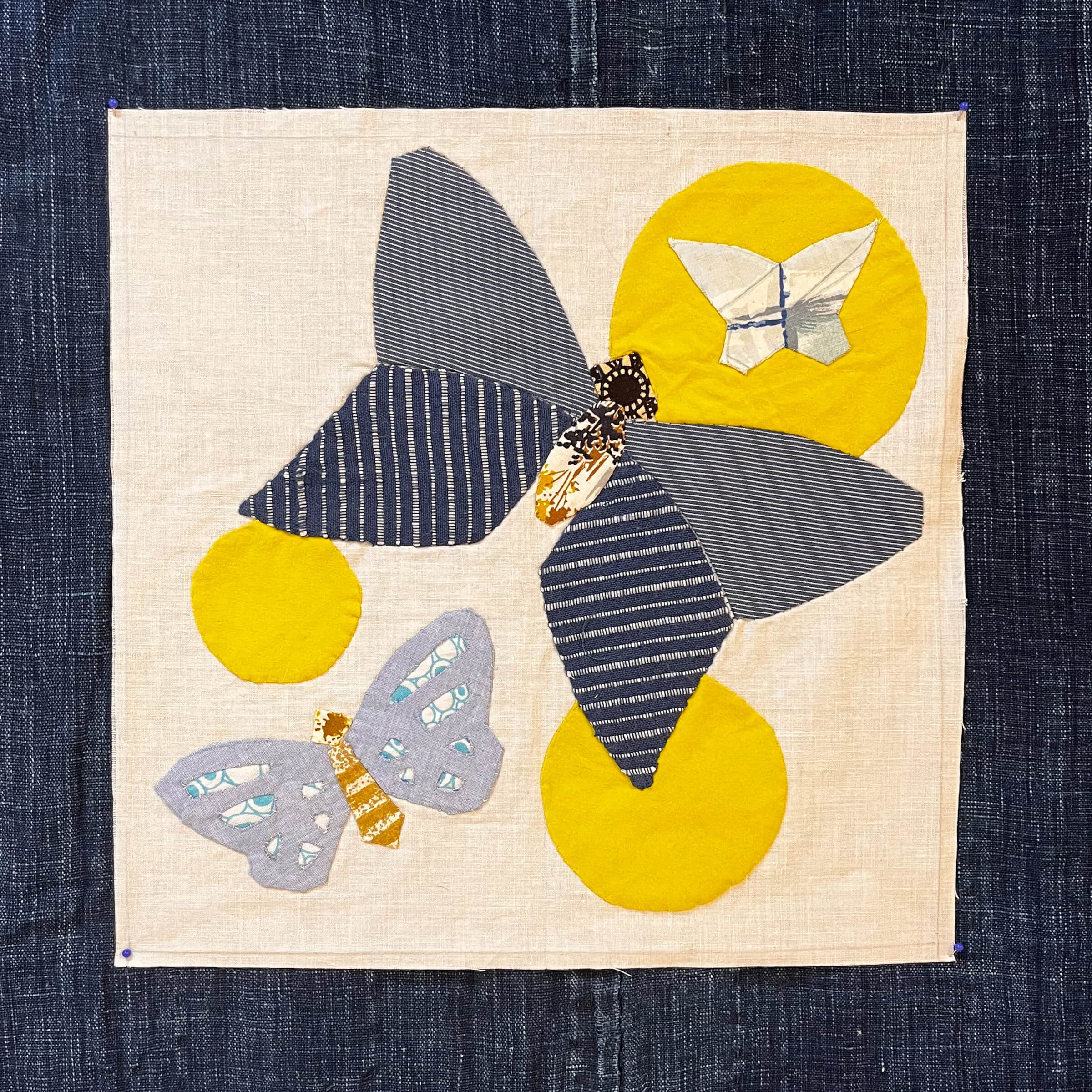 Fabric applique of a butterfly with circles.