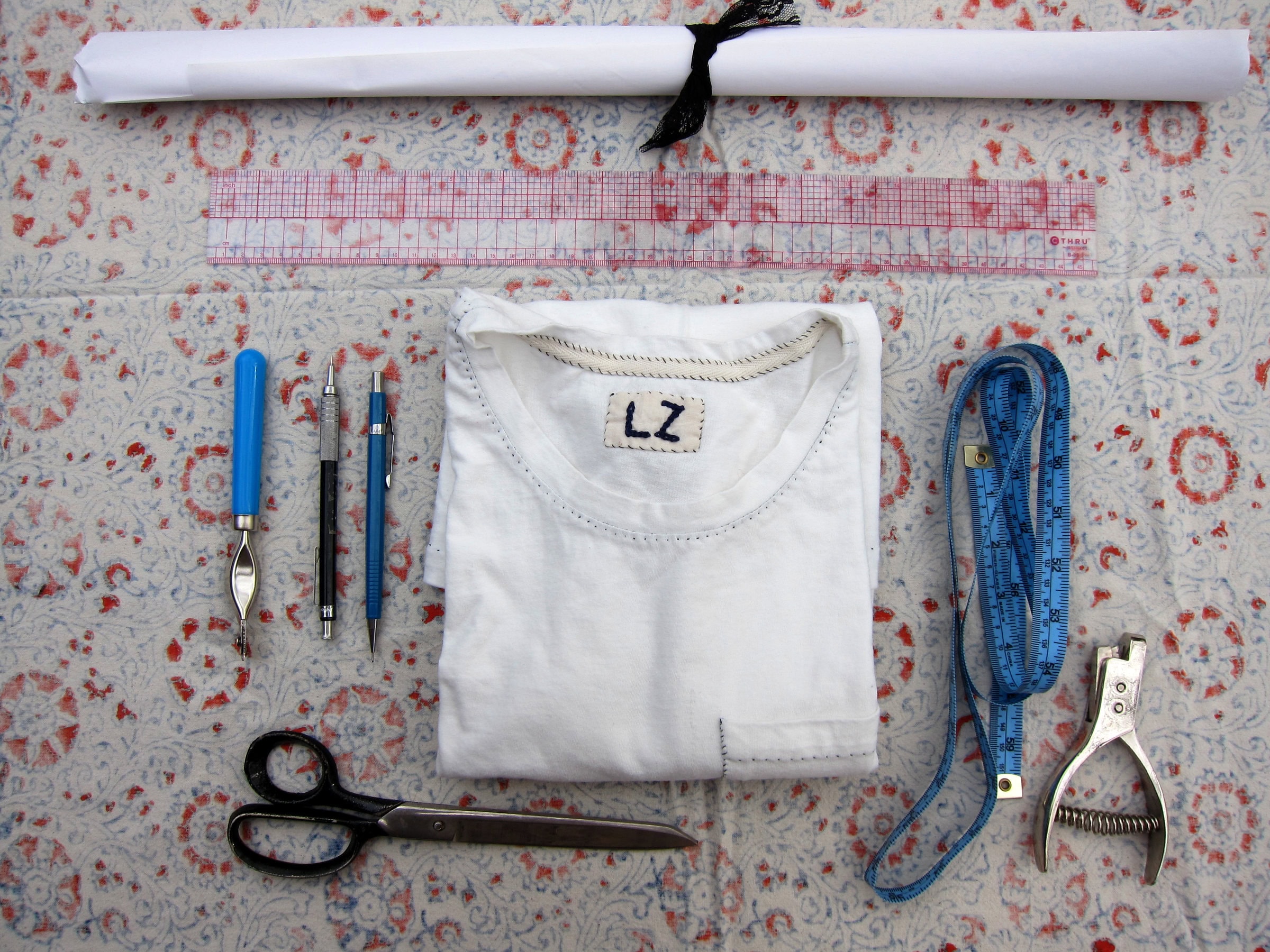 Sewing supplies on a patterned table cloth.