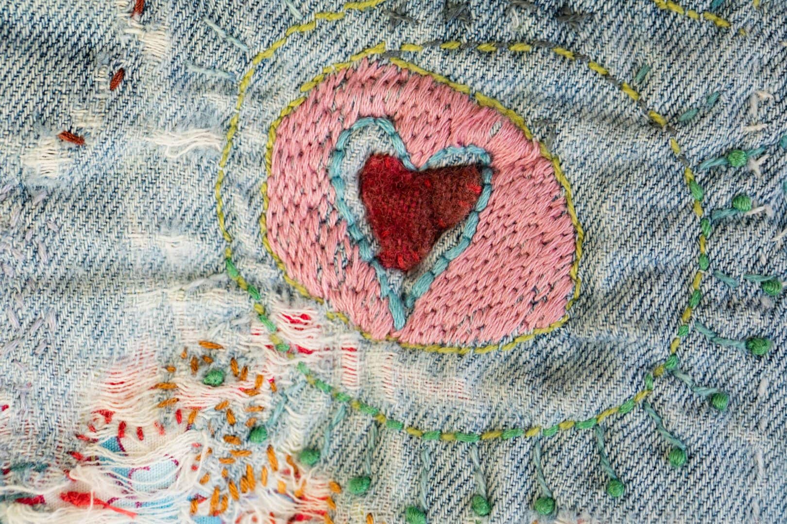 Embroidered heart on denim fabric.