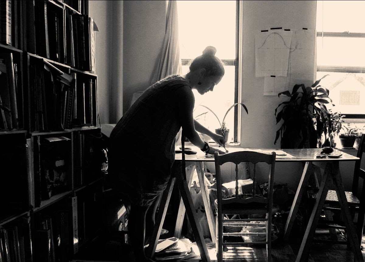 Woman working on a table with bookshelves