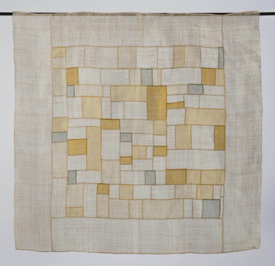 Beige and gold patchwork textile hanging.