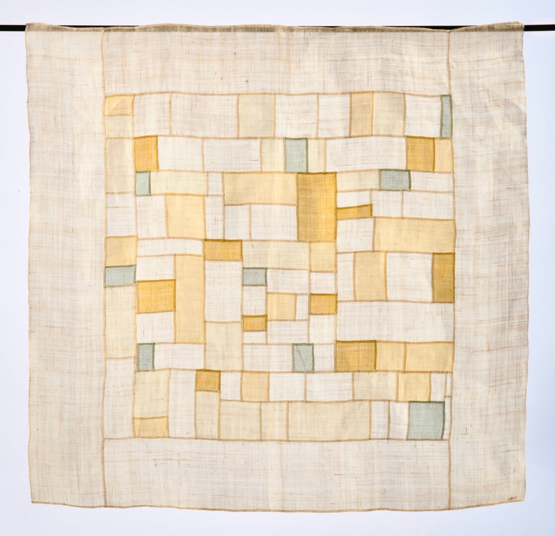 Beige and gold fabric patchwork hanging.