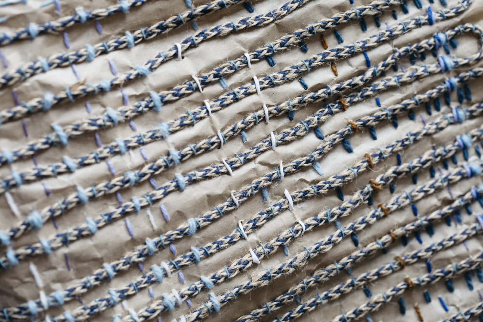 Blue and brown rope stitched on paper.