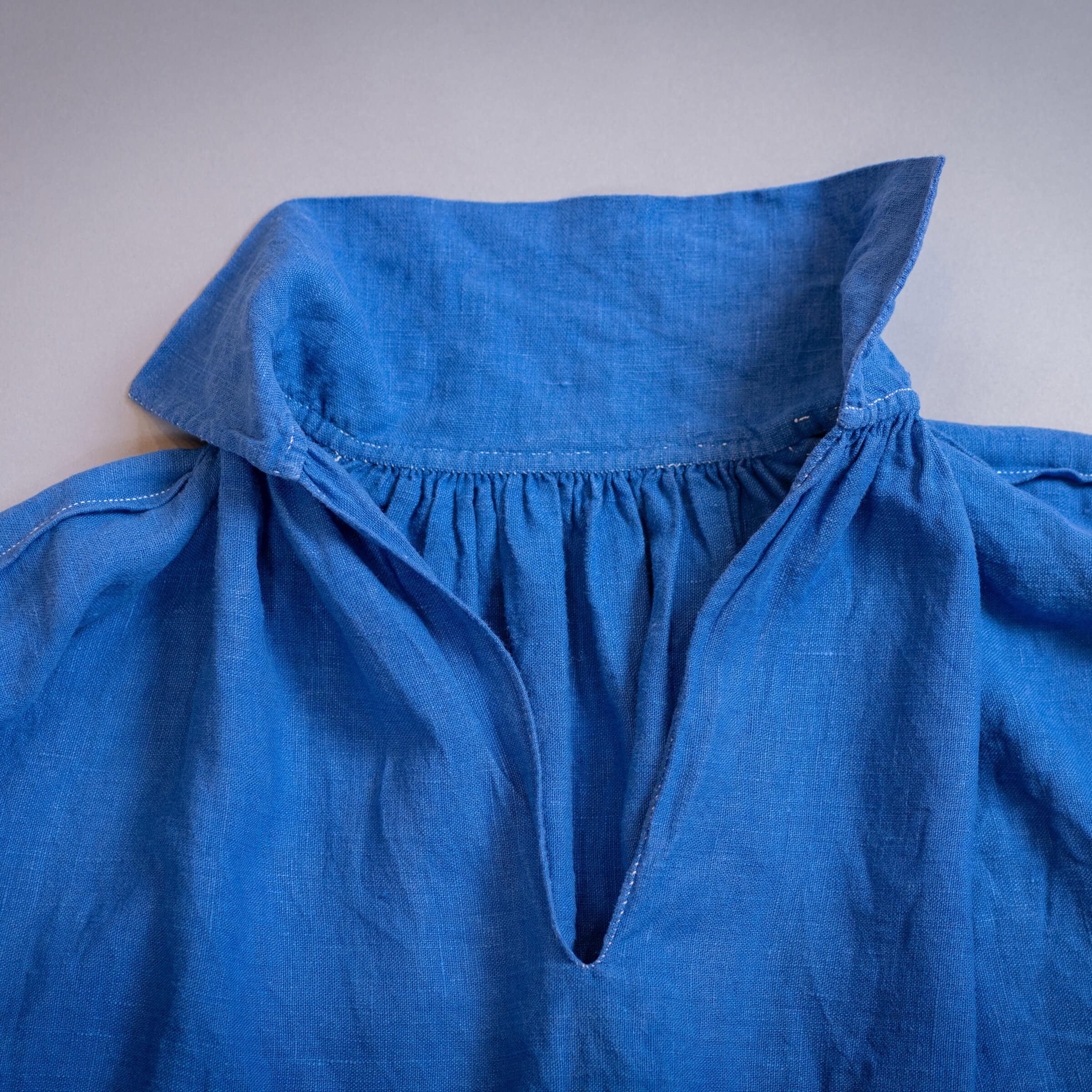 Blue linen shirt with a collar.