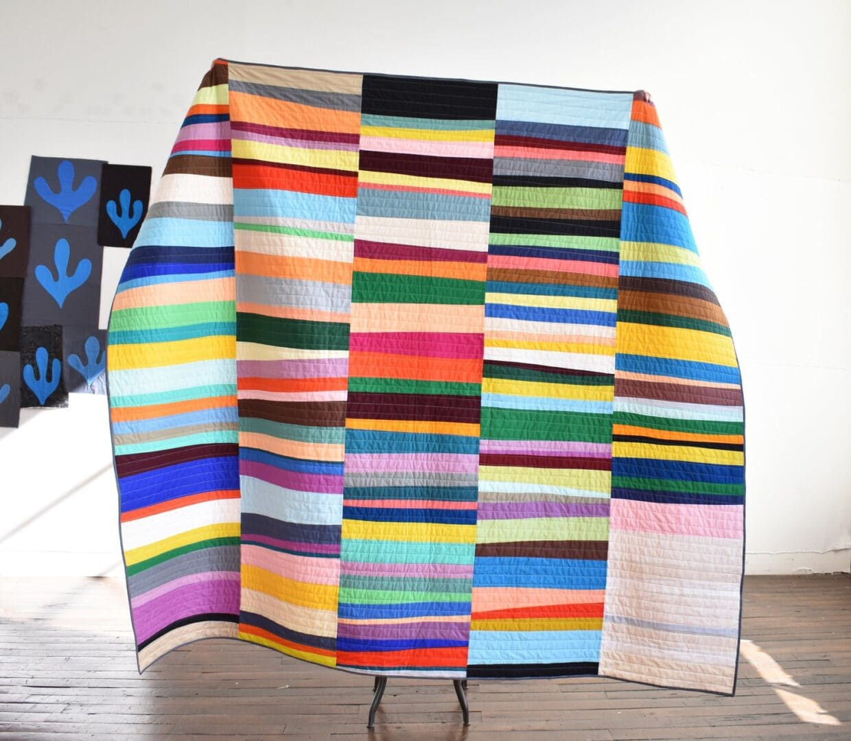 Colorful striped quilt on wooden floor.