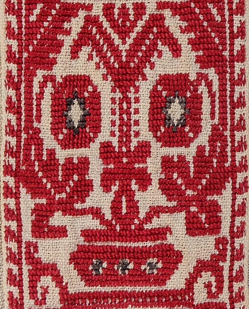 Red and white embroidered textile pattern.