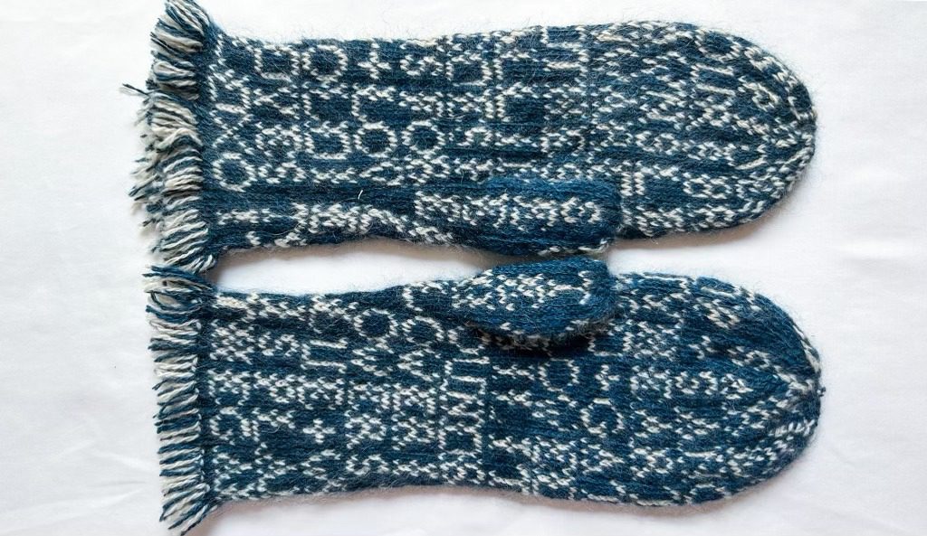 Blue and white knitted mittens with fringe.