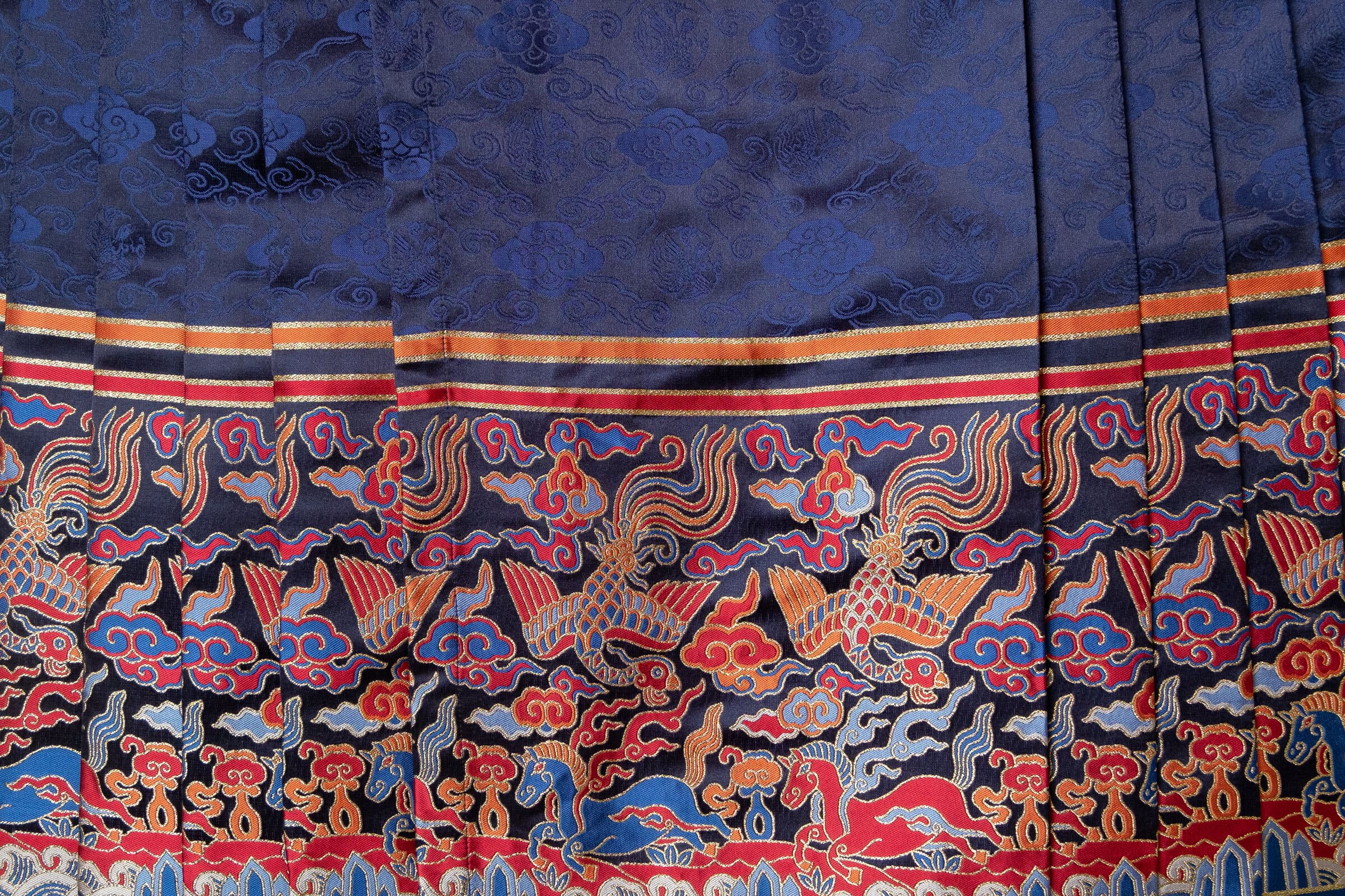 Blue fabric with gold and red embroidered designs.