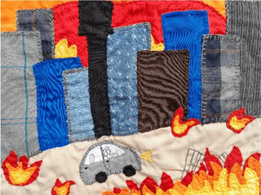 Fabric patchwork depicting burning city.