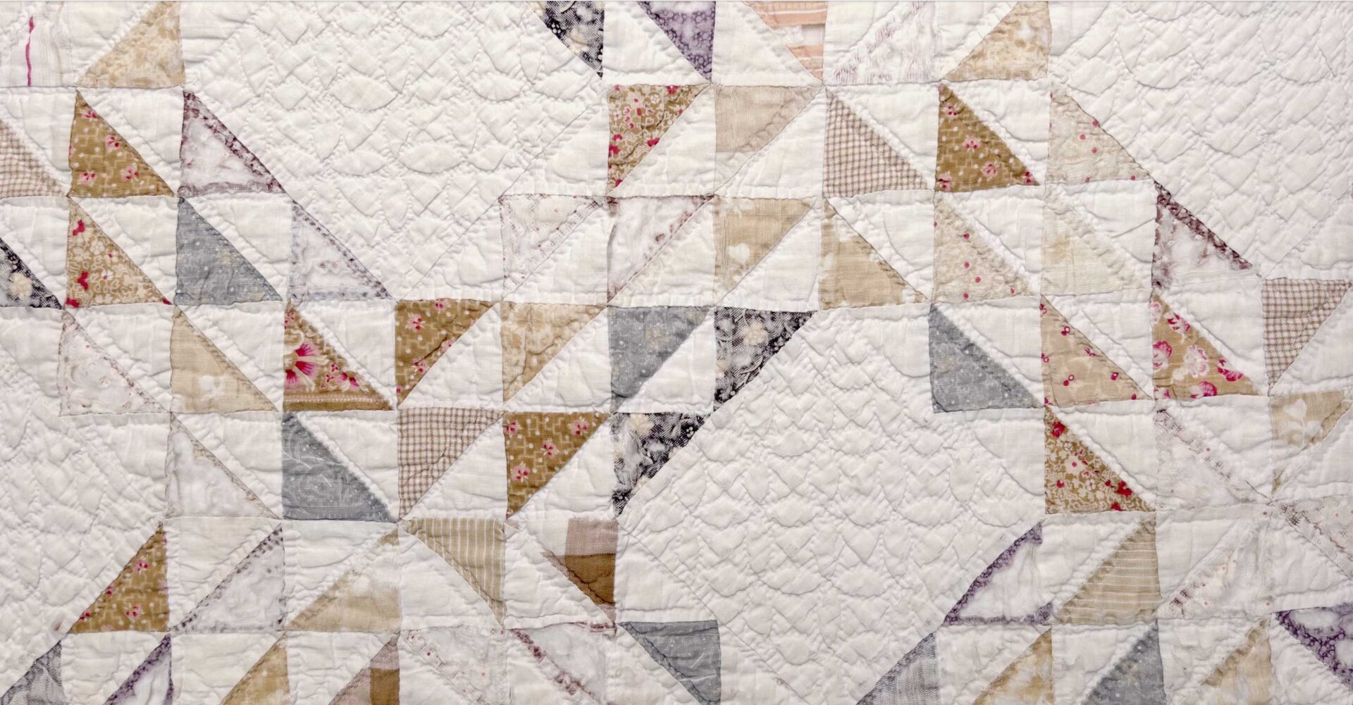 White patchwork quilt with triangle pattern.