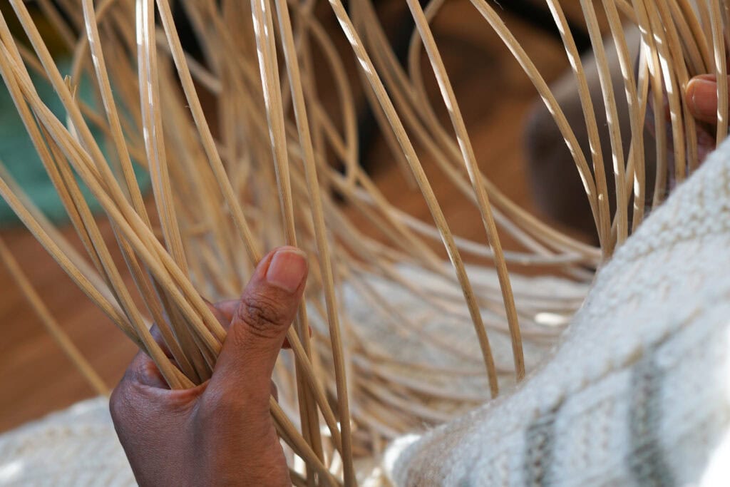 Hand weaving with wooden sticks.
