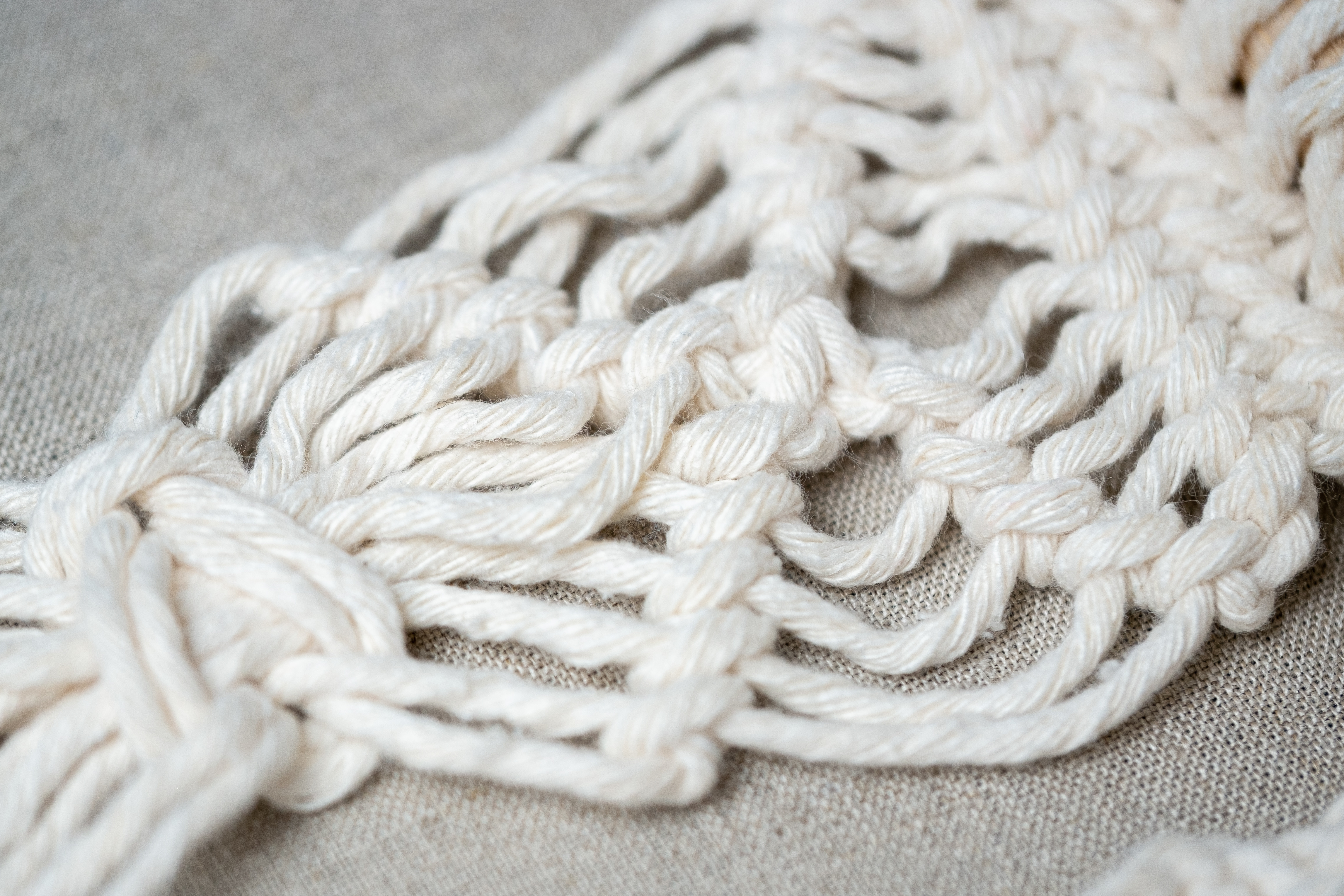 Close-up of white macrame knotting.