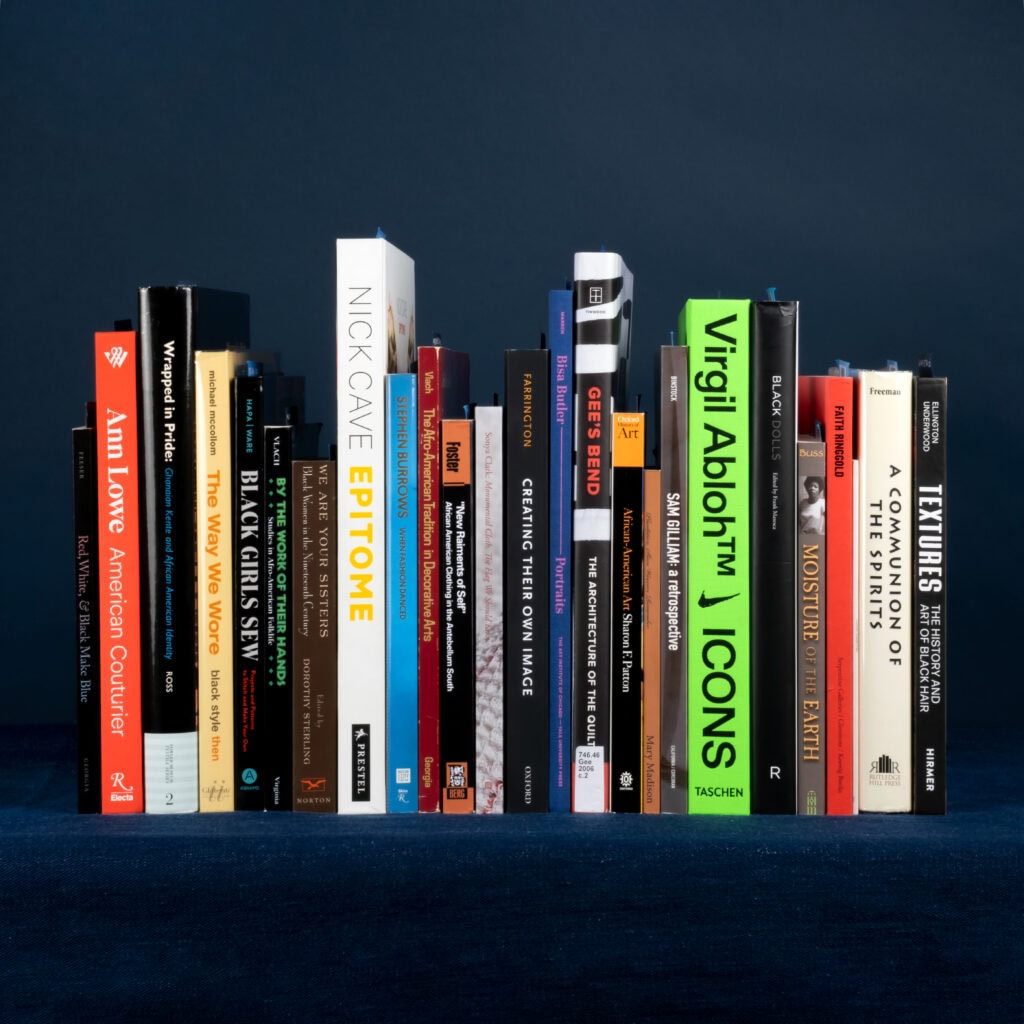 Row of books on dark blue shelf.