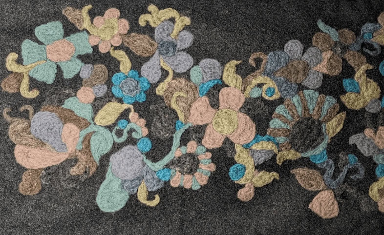 Woolen floral embroidery on black fabric.