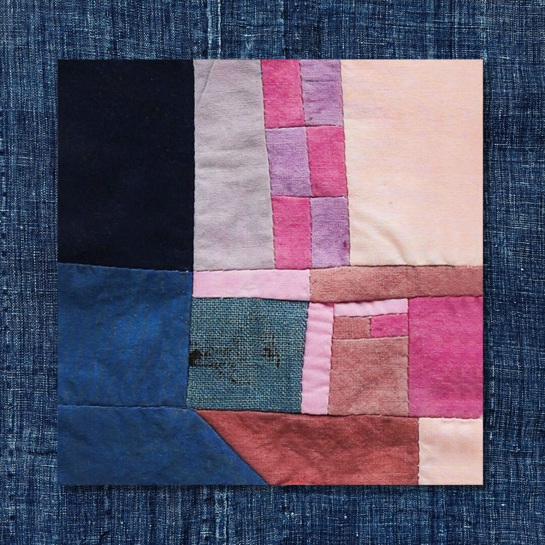 Patchwork quilt with blue, pink, and red fabric.