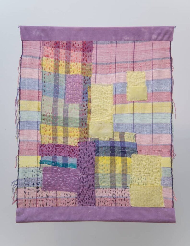 Purple and yellow patchwork quilt art.