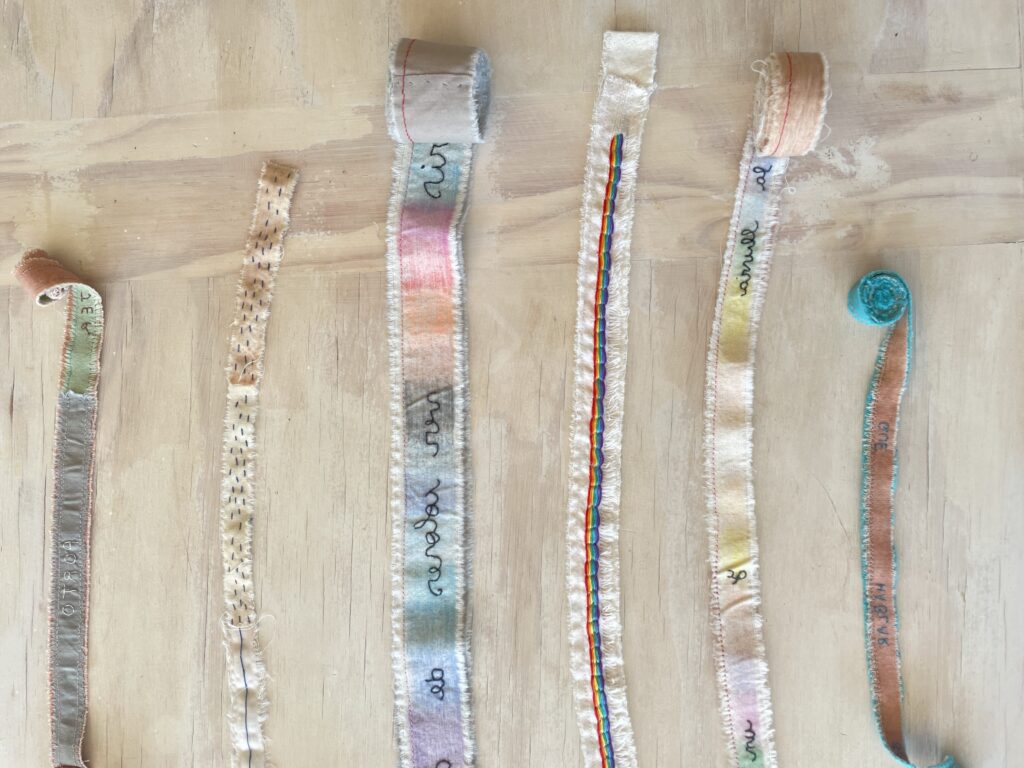 Fabric strips with embroidered words.