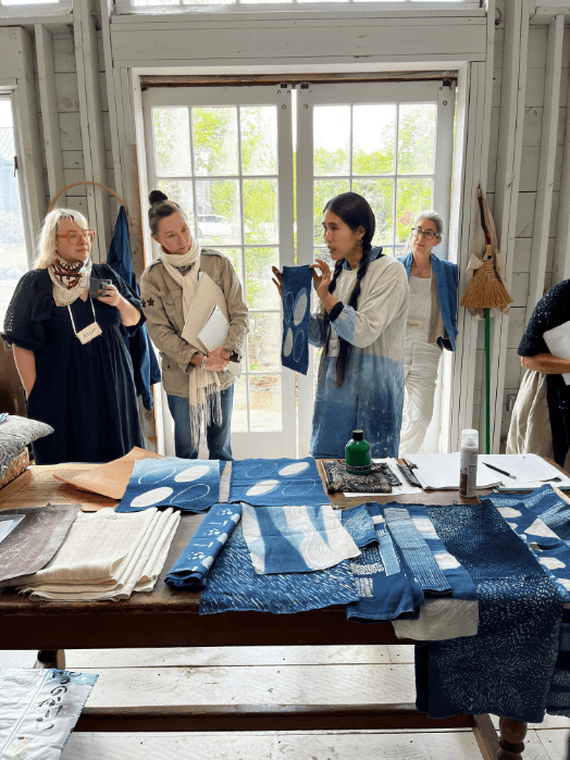 Women discussing indigo dye fabric samples.