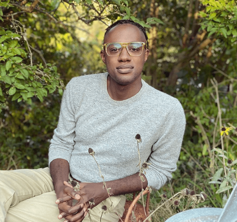 Man wearing glasses in a garden.