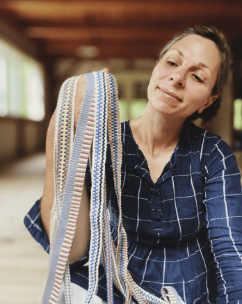 Woman holding colorful woven straps.