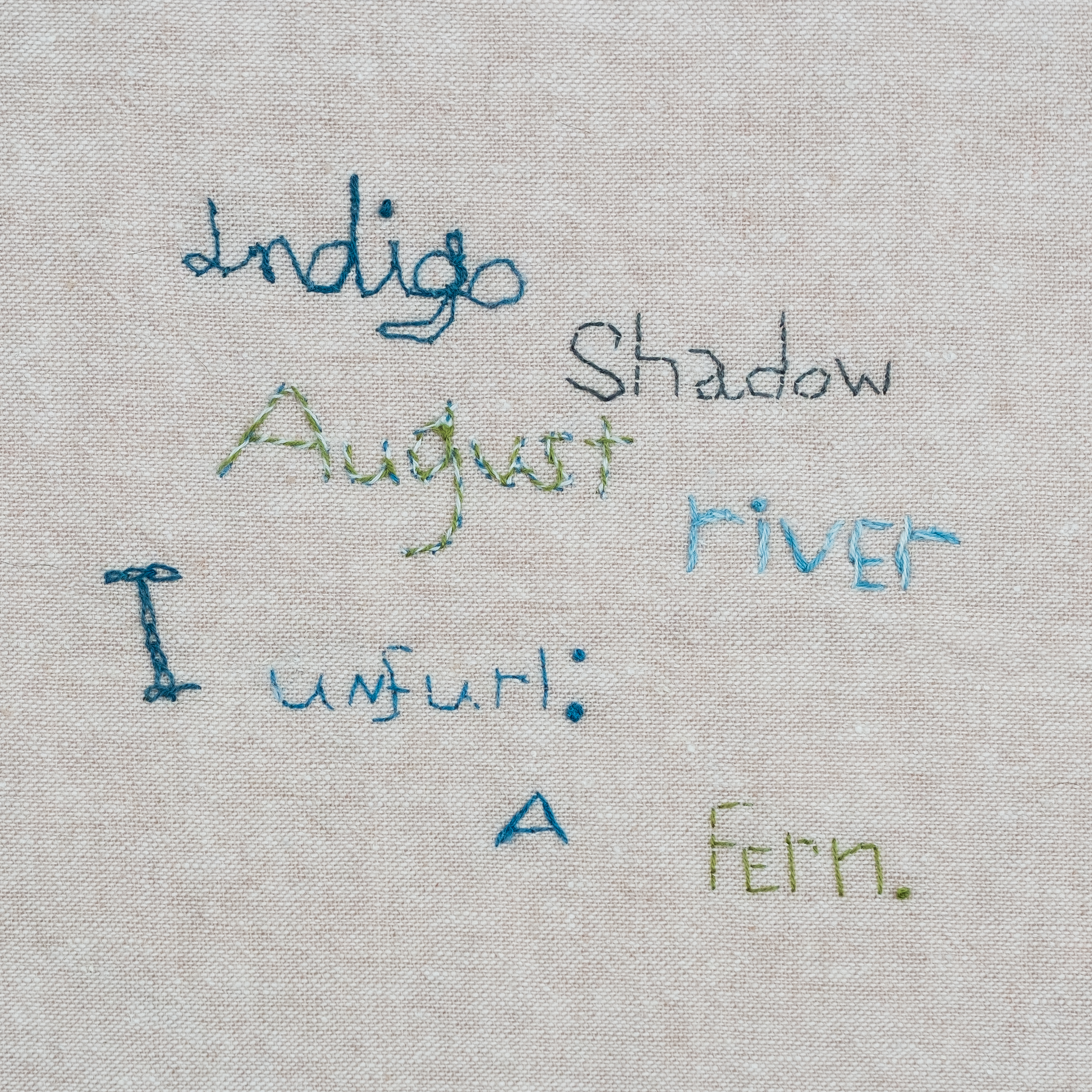 Embroidered words on fabric background.