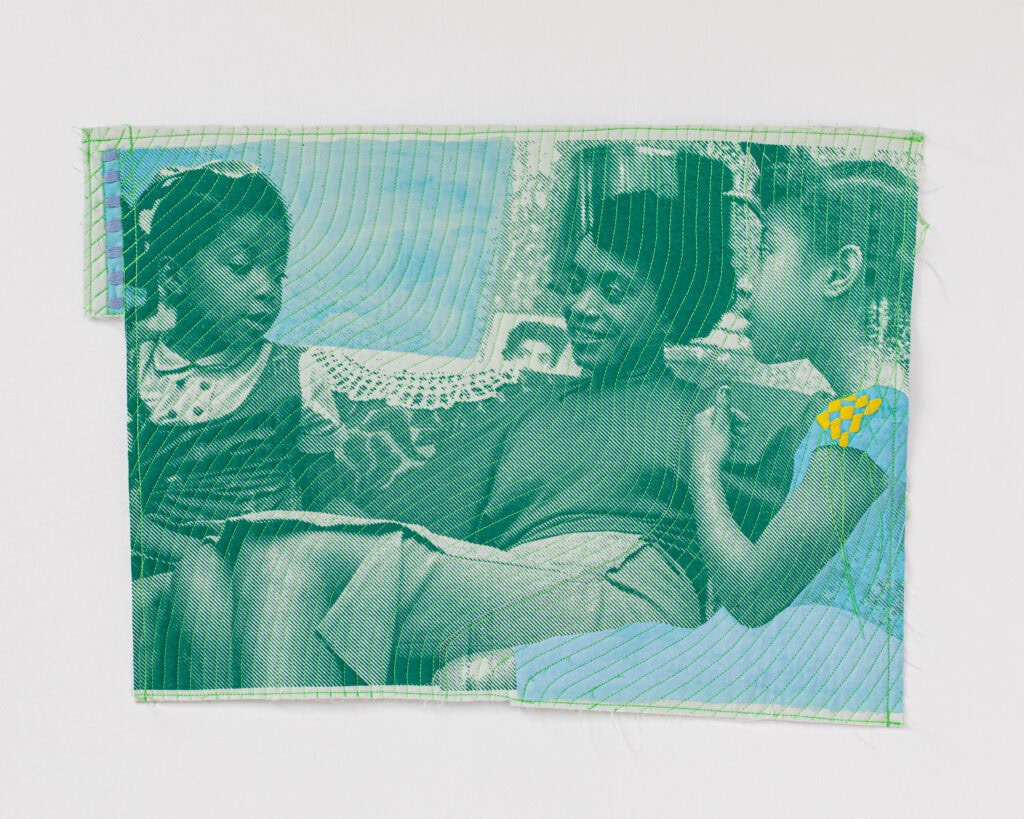 Two girls smiling, green fabric background.