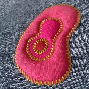 Pink fabric number eight with gold stitching.