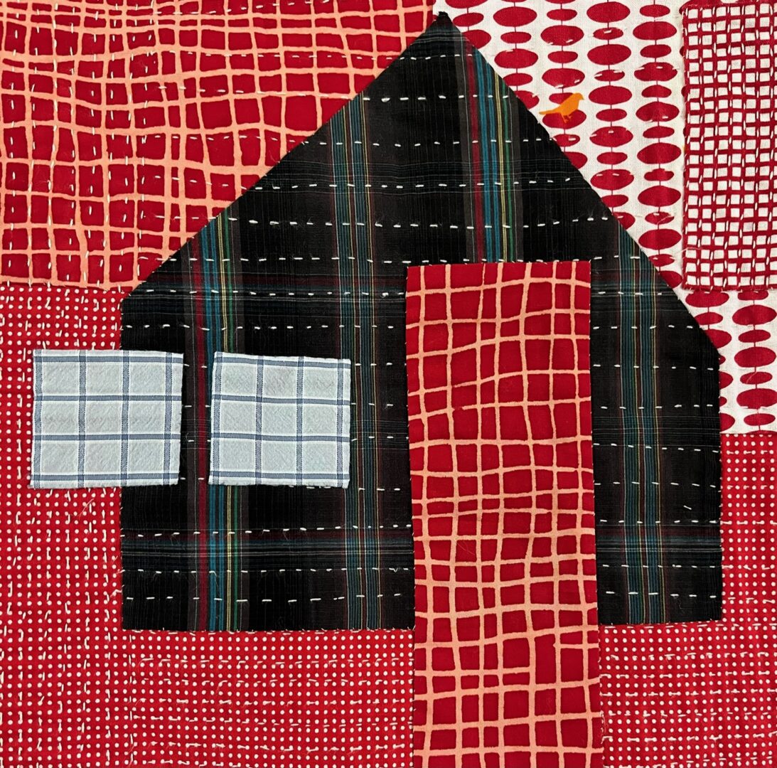 Red and black quilt with a house shape.