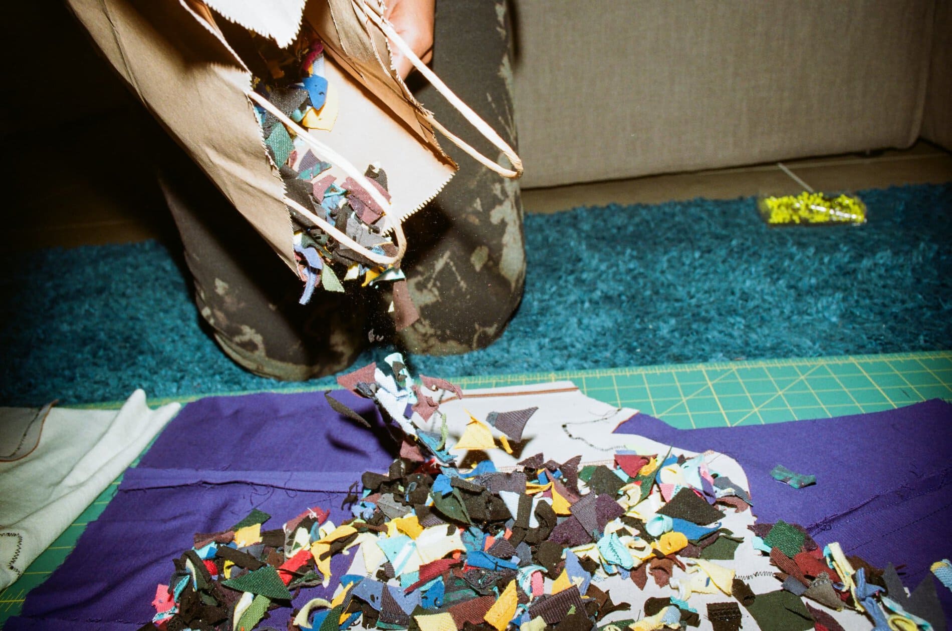 A bag of small scraps of fabric emptying in a pile on the floor.
