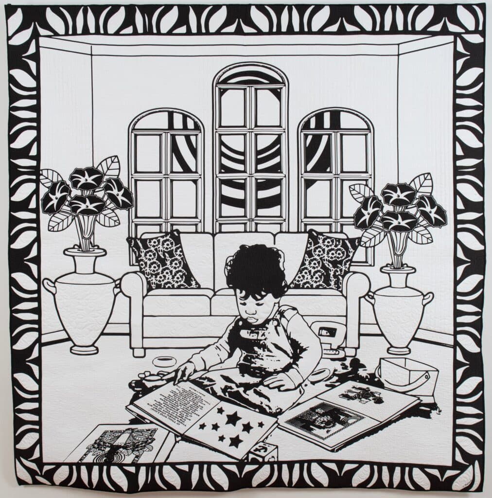 Black and white quilt of a child sitting in a house surrounded by books and plants (front and back).
