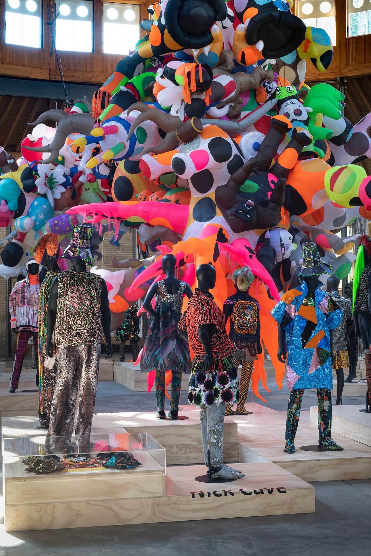 Mannequins in Nick and Jack Cave’s The Color Is exhibition at the DuSable Museum wear colorful clothing designed by the brothers against a background of colorful blown-up props.