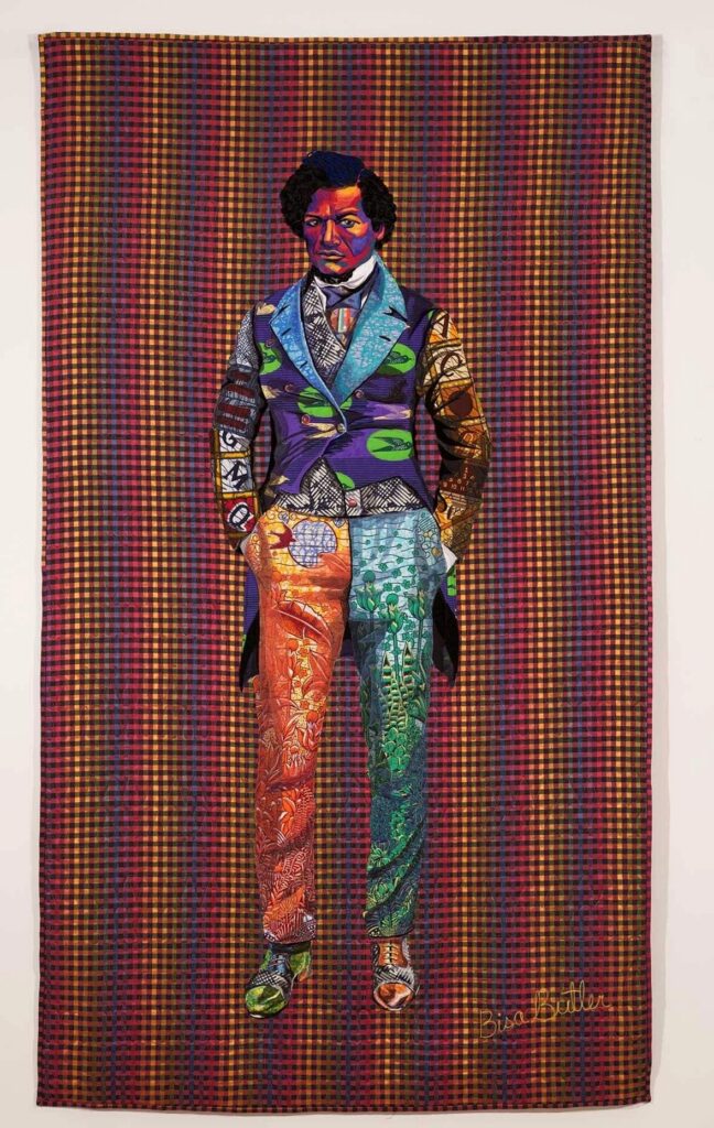 Quilted portrait of Frederick Douglass in a colorful patterned suit against a checkered rainbow background. Bisa Butler, The Storm, the Whirlwind & the Earthquake.
