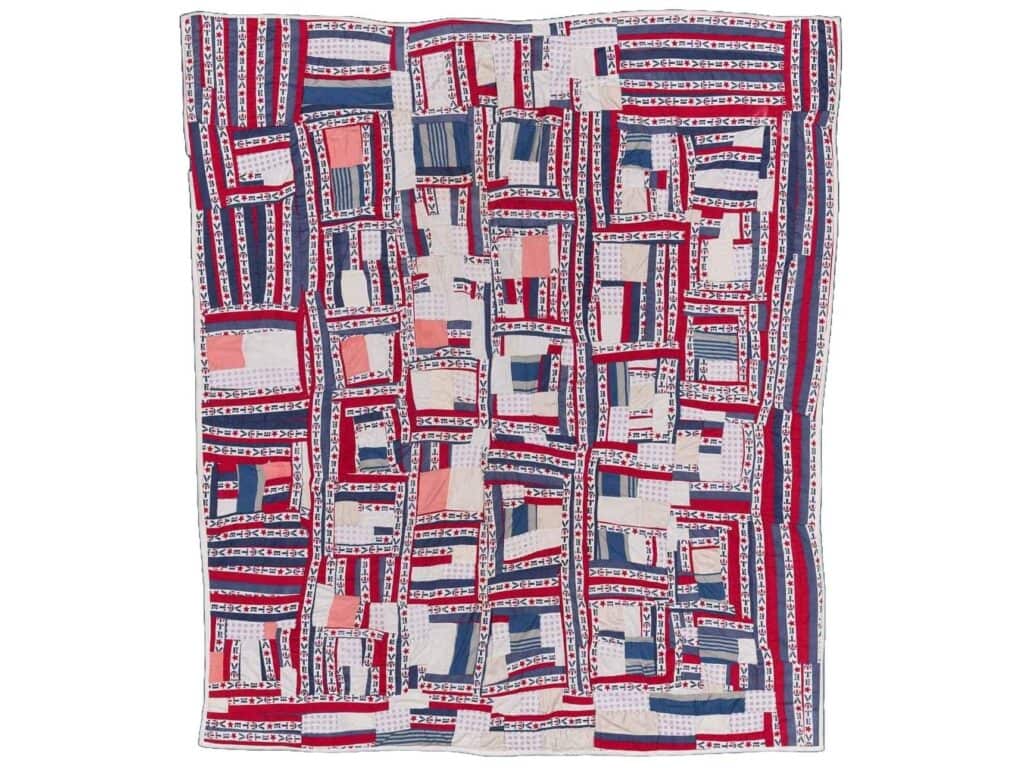 A red, white, and blue quilt pieced with colored fabric and thin strips reading “VOTE.” Irene Williams, Vote Quilt.
