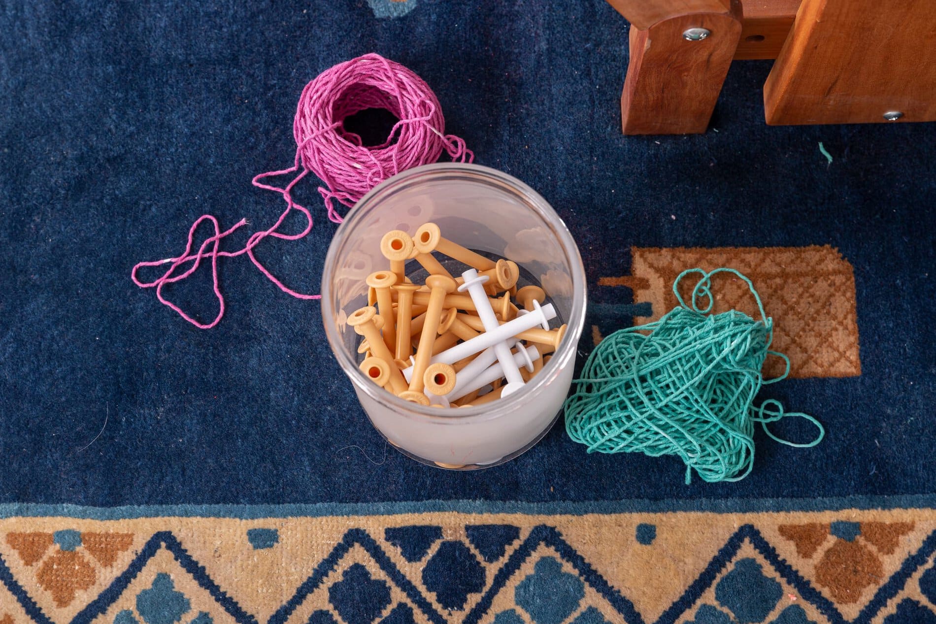 A plastic container holding weaving notions.