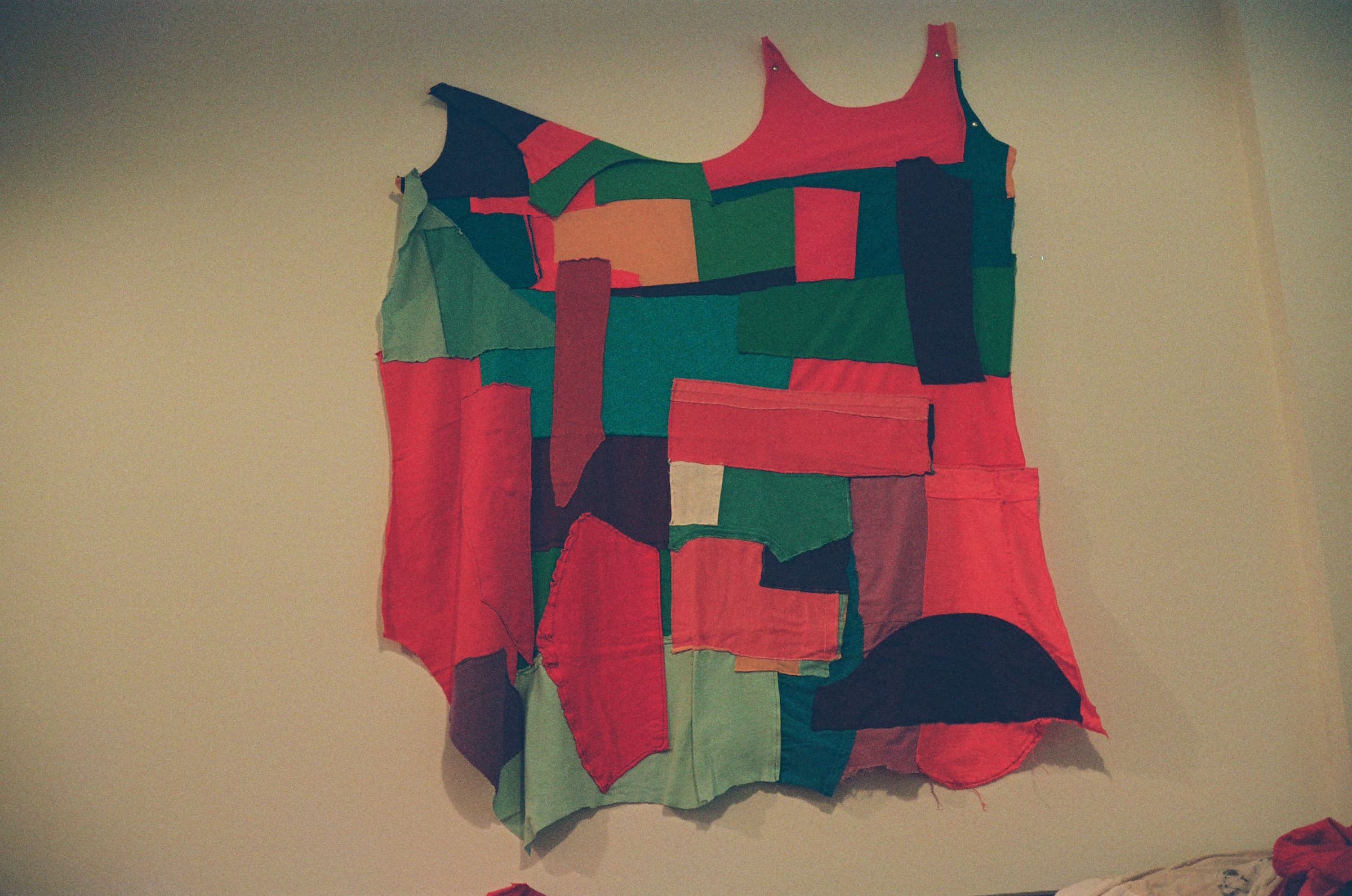 A colorfully pieced work of art hanging on a wall.