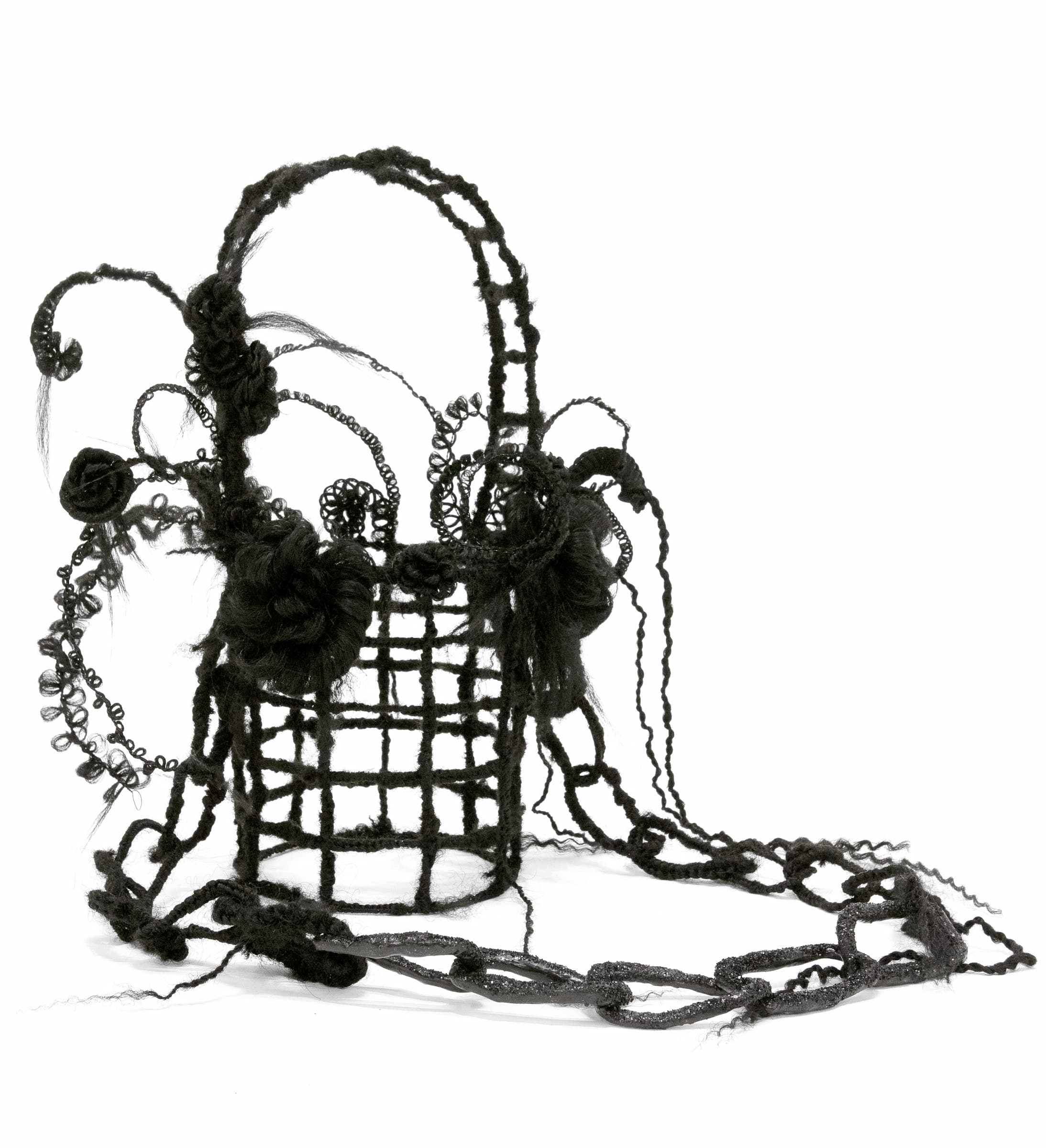 A bottomless round basket wrapped in black synthetic hair with curls of black synthetic hair and a glittery black chain attached.