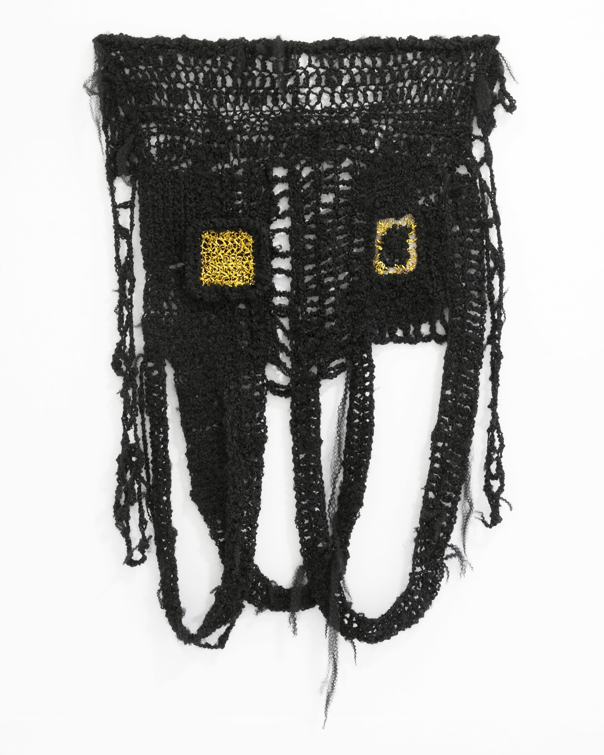 A weaving made of black synthetic and natural hair and gold wire.
