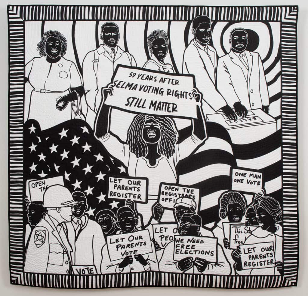 Black and white quilt depicting black protesters holding signs for voting freedom in front of an American flag (front and back).